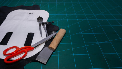 Work table. Designing a leather bag, with scissors, thread, compasses and cutter. In perspective
