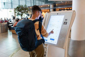 Traveler using touch screen at airport.