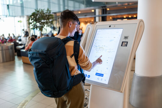 Traveler using touch screen at airport.