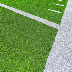 Football Field Turf. Bright green turf football field with white sidelines and yard line markings. Angled overhead view.