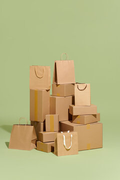 Shopping bags and cardboard boxes stacked on the green background