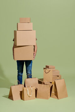 man hold parcel and stay near a stack of boxes