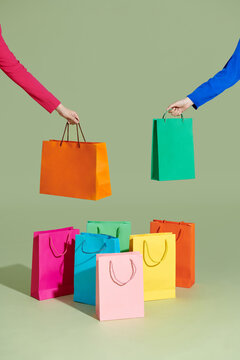 Shopping bag logo. Hand holding a shopping bag on green background