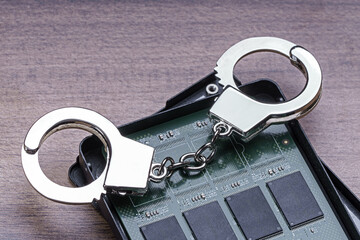 Open solid-state drive with handcuffs. Punishment for theft of personal data and information concept - 777700685