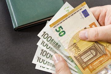 Holding euro cash in close-up over table