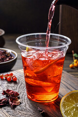 Hibiscus tea pouring.Herbal tea made as an infusion from crimson calyces of roselle flower - 777701219