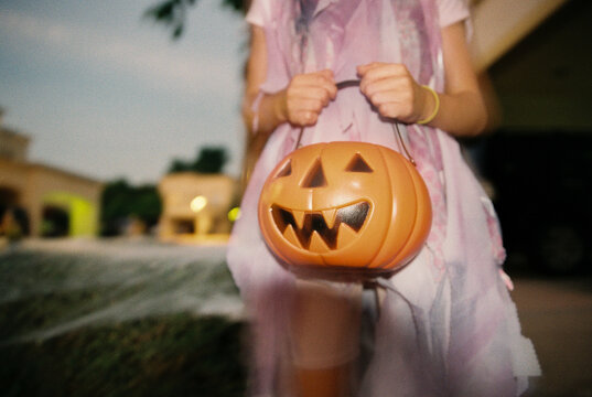 An anonymous girl in a costume with a Halloween bag