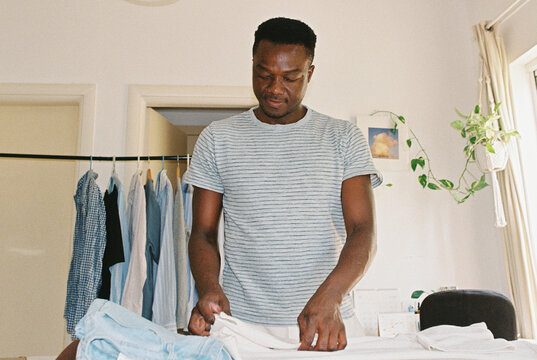 A man folding clothes on an ironing board