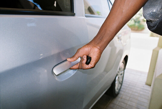 A man opening a car door.