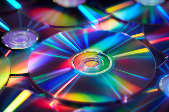 Multiple compact CD discs scattered in studio with holographic effect