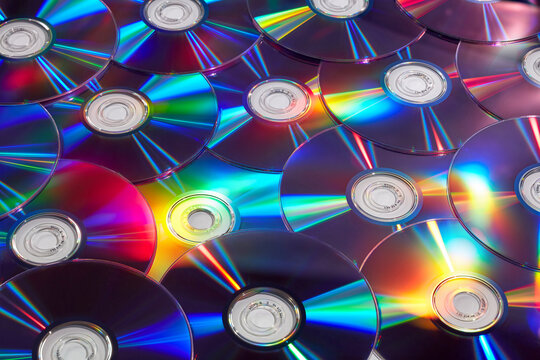 Randomly arranged vintage compact discs with colorful lights