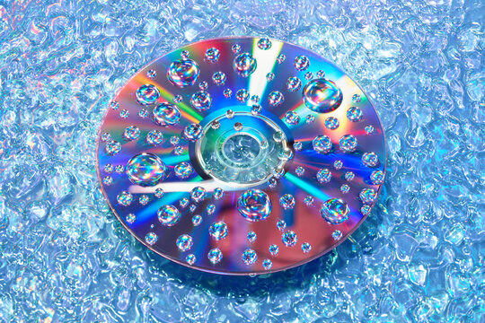 90s CD disc submerged in water reflecting rainbow light