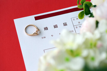 Japanese marriage registration blank document and wedding proposition ring and flowers on table close up