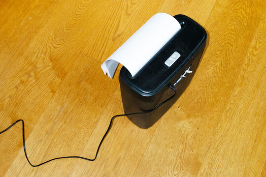 Paper shredder shredding/chipping paper on office floor and flashlight