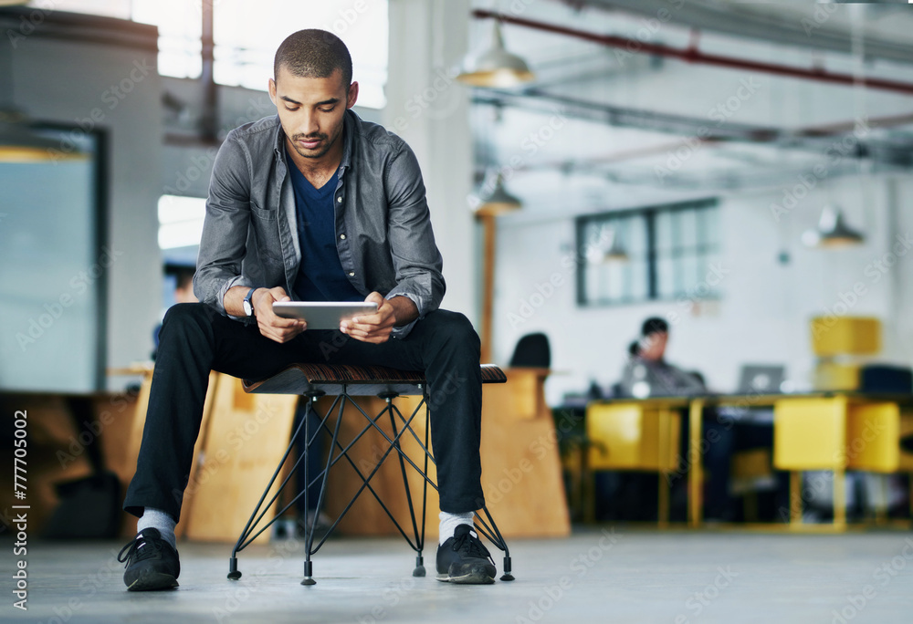 Poster Man, office and chair with tablet in open space for break on internet or online for research as graphic designer. Employee, browse and website for projects creativity or ideas for design agency