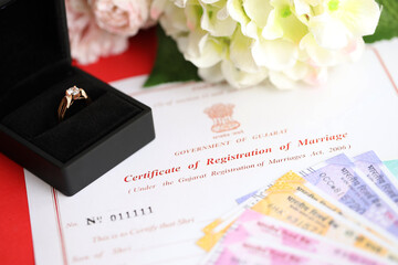 Indian Certificate of registration of marriage blank document and wedding ring with rupiah money on table close up