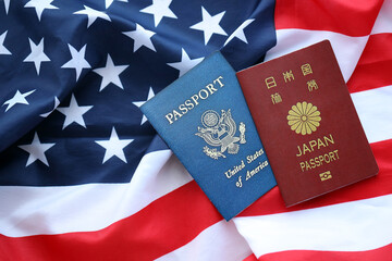 Fototapeta na wymiar Passport of Japan with US Passport on United States of America folded flag close up