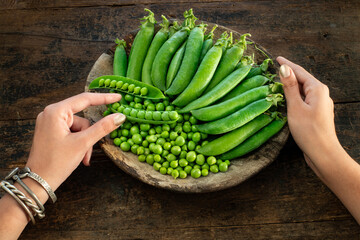 Green peas in the wood bowl. Bezelye  - obrazy, fototapety, plakaty