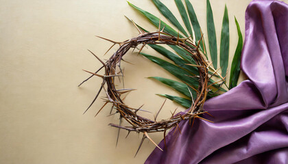 Crown of thorns with palm leaf and purple fabric on a beige background. Top view, flat lay with a...