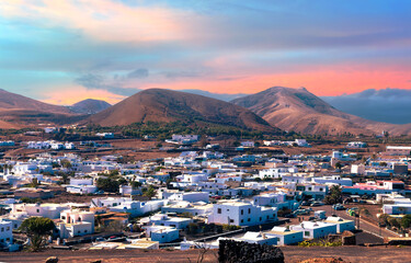 Landscape aerial view of the Municipality of Yaiza village illuminated by the sunset at the foot of...