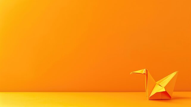 Orange origami crane on orange background with soft shadow