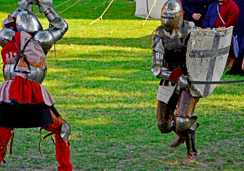 rekonstrukcja walk rycerzy na festynie, walka rycerzy, reenactment of knights' fights at the festival, people in knights' costumes fight during a historical reenactment at the Medieval Festival	