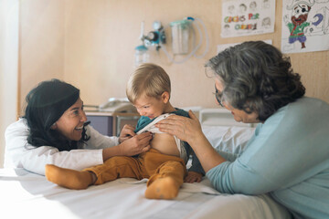 Doctor Examining child With Stethoscope In Hospital