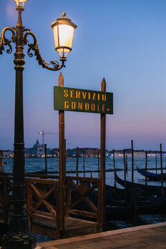 Gondola ride service stand and sign on waterfront of Venice