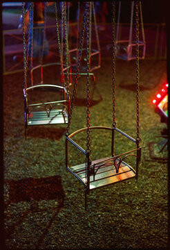Night shot with chain carousel seats in an amusement park