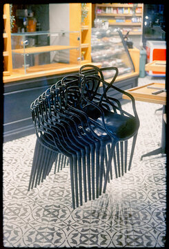 A stack of chairs in a closed cafe on a beautiful tile