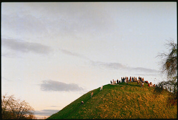 People are diligently climbing up the picturesque hill to the top