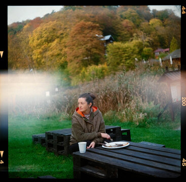 Film portrait with a woman on a picnic in the autumn forest
