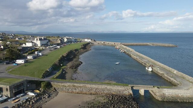 A wide drone shot of a pier and an Irish seaside village on a sunny day. Mullaghmore Co. Sligo, Ireland