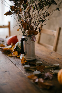 dried fall flower arrangement on table with stone wall 