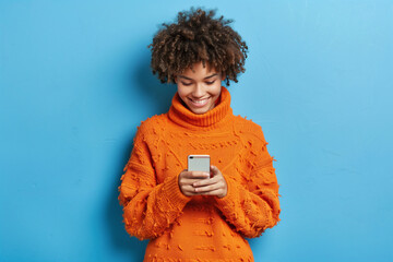 Smiling Woman Enjoying Social Media on Her Phone