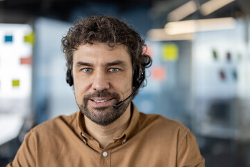 Professional male customer support representative wearing a headset, with a confident smile in a...