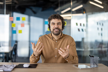 Smiling male professional with headset engaging in a business conversation in a contemporary...