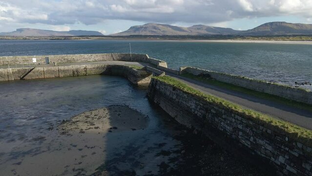 A close up drone shot of the pier at Mullaghmore Co. Sligo with Benbulben mountain in the background. 