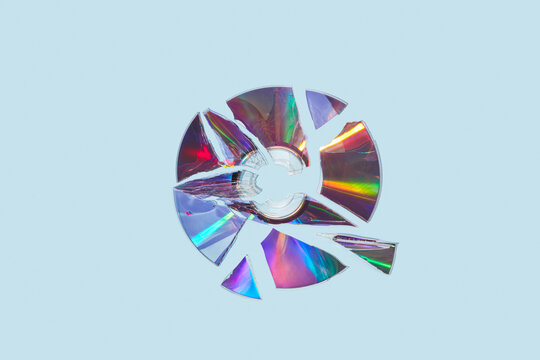 Damaged plastic compact disc scattered with pieces in studio