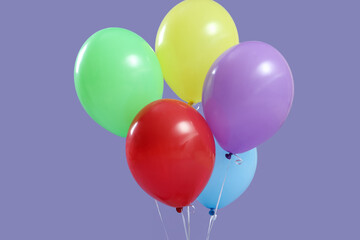 Bunch of colorful floating balloons on lilac background