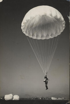 1969.  Parachutist prepares for landing.
