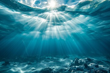 Strong sun beams streaming through the surface of the ocean rancing from bright white to deep...