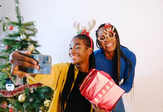 Smiling Friends taking selfie with Christmas funny tiaras