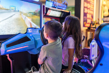 Little Kids Playing Racing Simulator Game in Arcade Park.