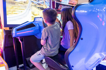 Little Kids Playing Racing Simulator Game in Arcade Park.