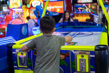 Energetic Play. Young Kids Enjoy Air Hockey Thrills at the Arcade Park