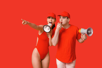 Lifeguards with megaphones and whistle spotted something on red background