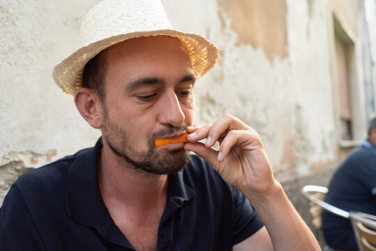 Man biting the orange slice of a spritz