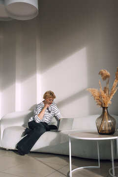 Coffee break: A woman is relaxing on the couch with a laptop