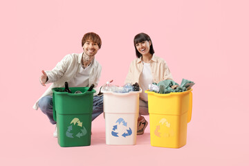 Young couple with containers for garbage sorting rubbish on pink background. Recycling concept